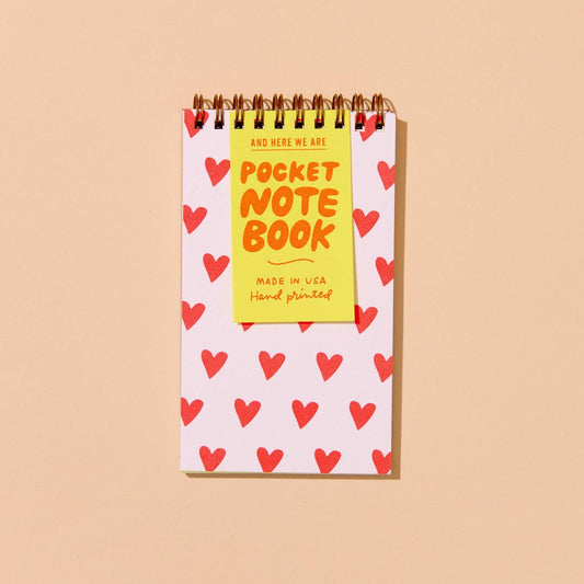 Small notebook with red heart patterns on a beige background